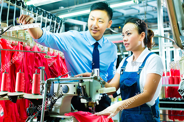 stock-photo-seamstress-is-new-assigned-to-a-machine-in-a-textile-factory-the-foreman-explains-something-165424334